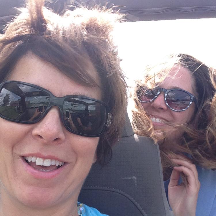 two people in convertible with wind-blown hair