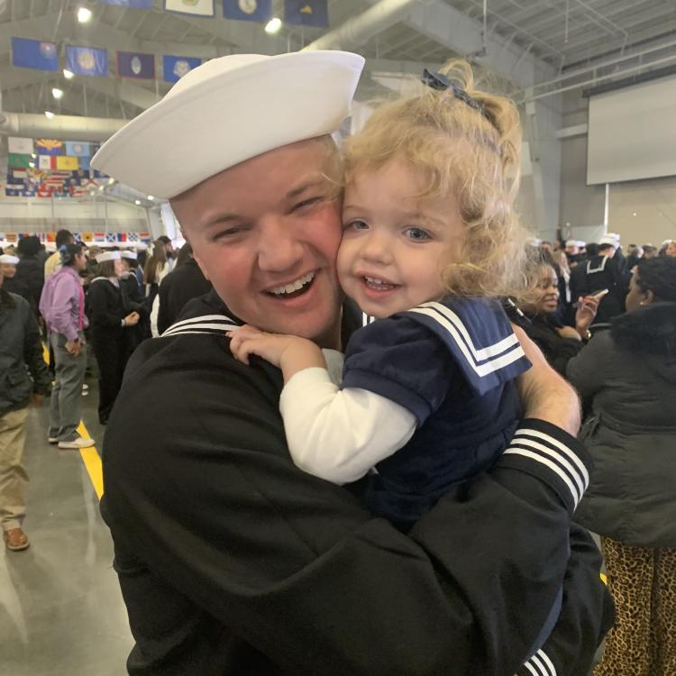man in sailor uniform hugging little girl in sailor dress