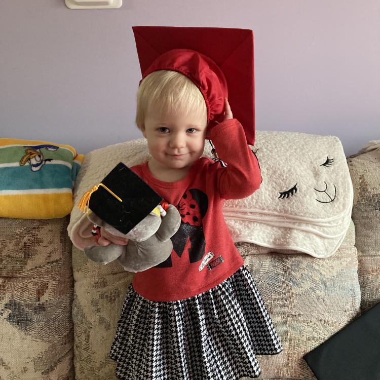 little girl in red graduation cap