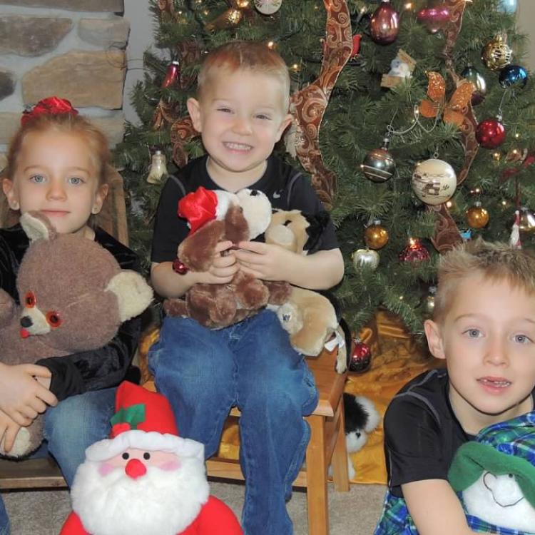 three children in front of Christmas tree