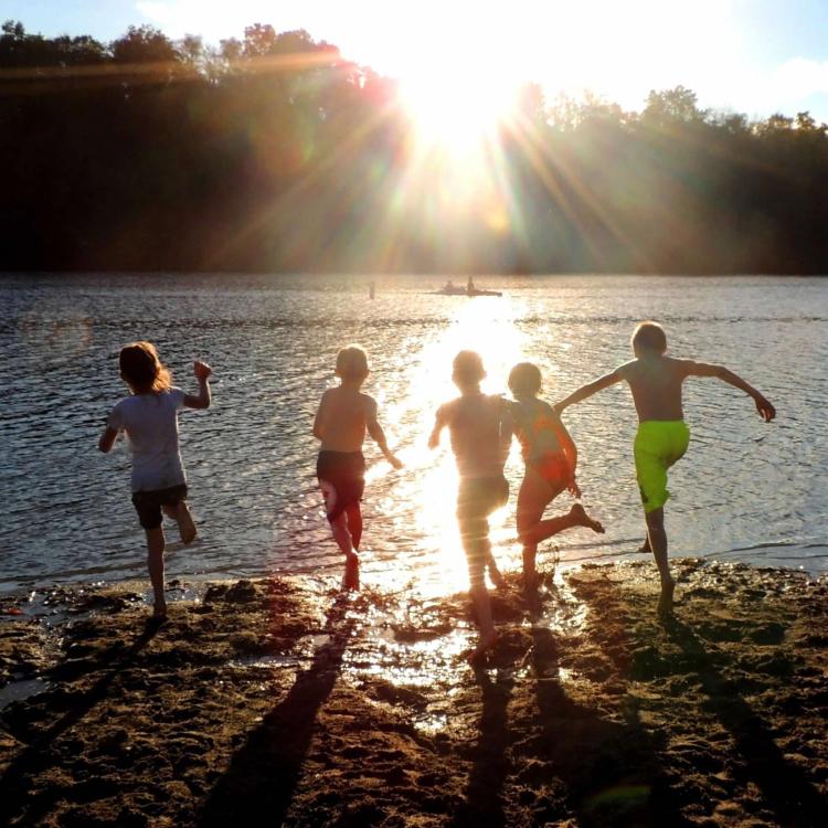 children running into lake