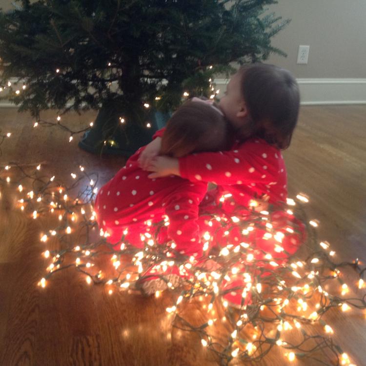 two small children in Christmas lights