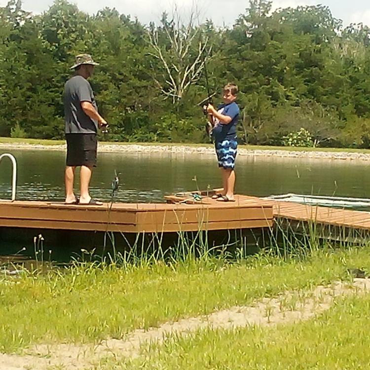 boy and man on dock with fishing gear