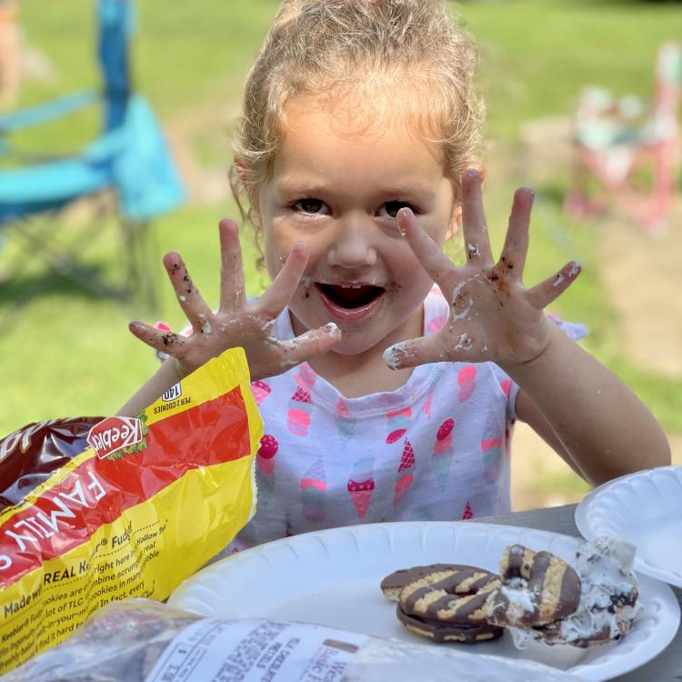 little girl with marshmallow on fingers