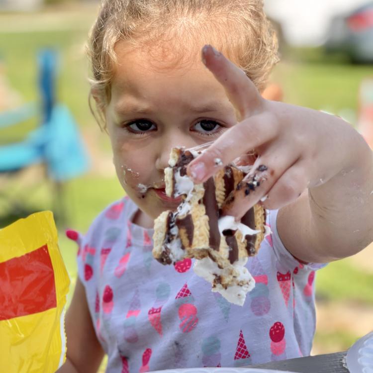 little girl holding sticky s'more