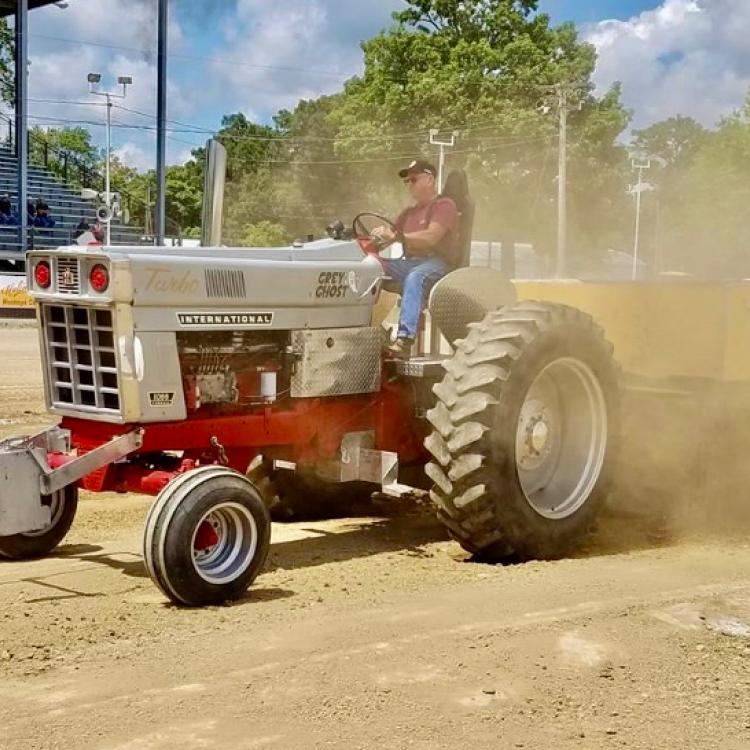 man on red and silver tractor