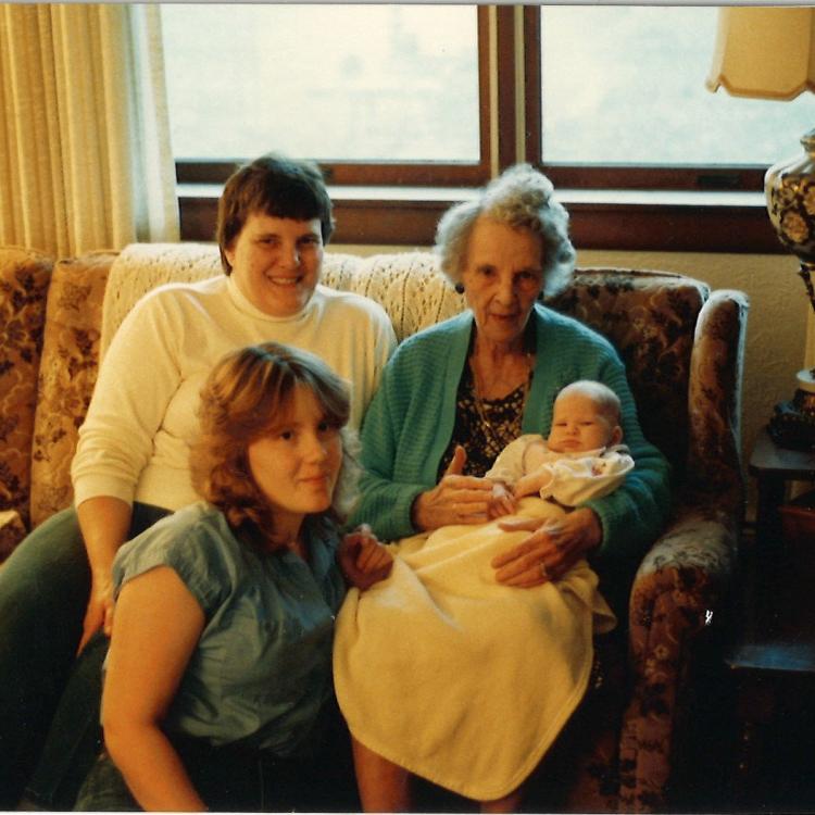 three women and a baby on a couch