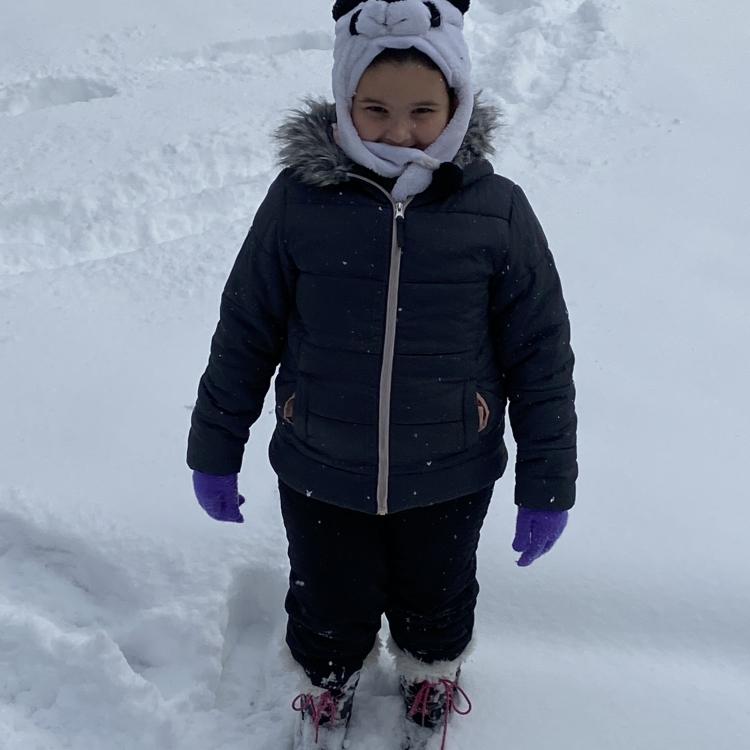 bundled up child standing in snow