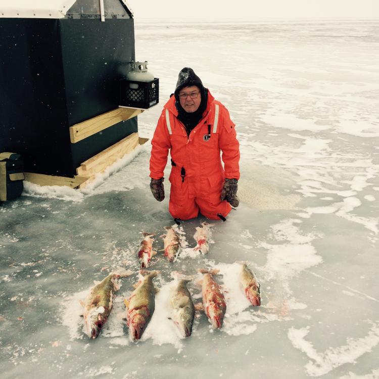 man on ice with fish