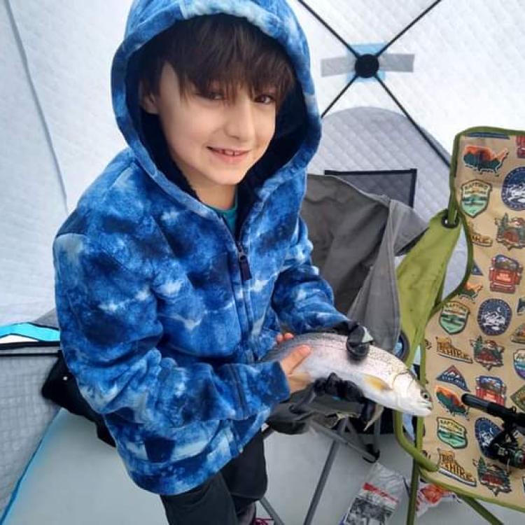 boy smiling holding a fish