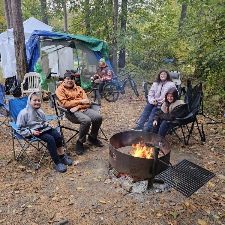 four children gathered around campfire