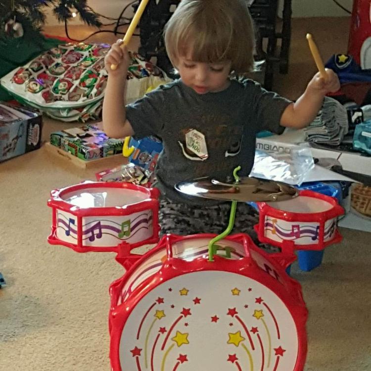 little boy at toy drum set