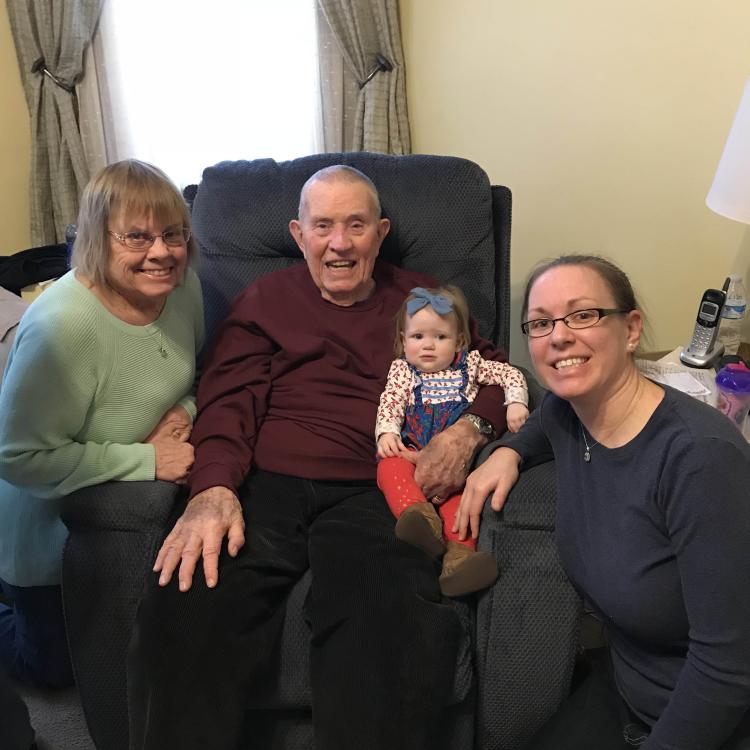 two women and a man holding a baby girl