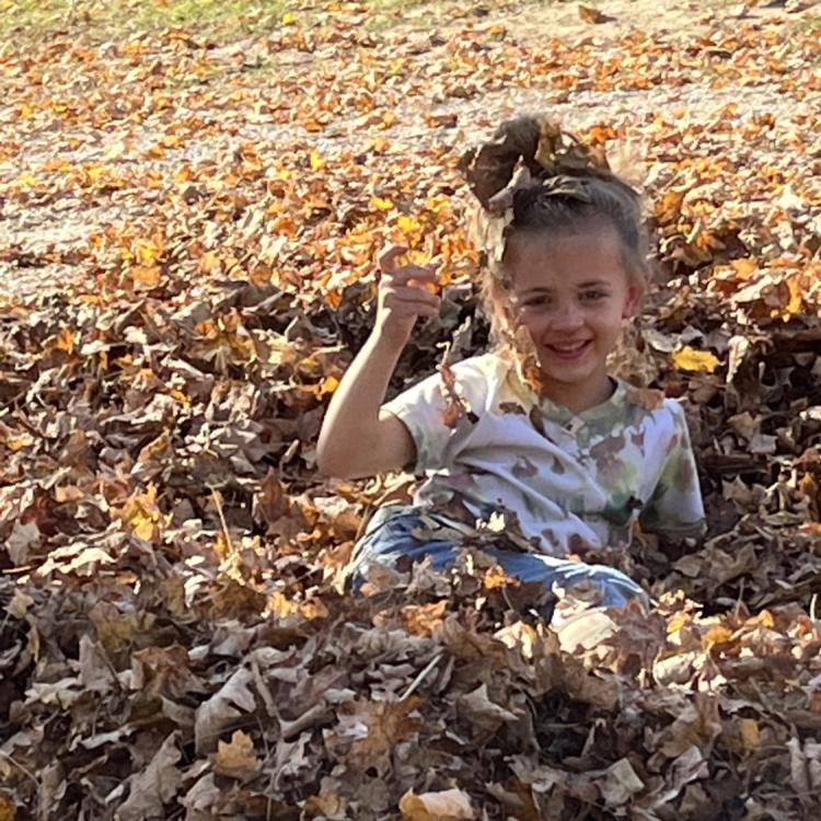 girl in leaf pile