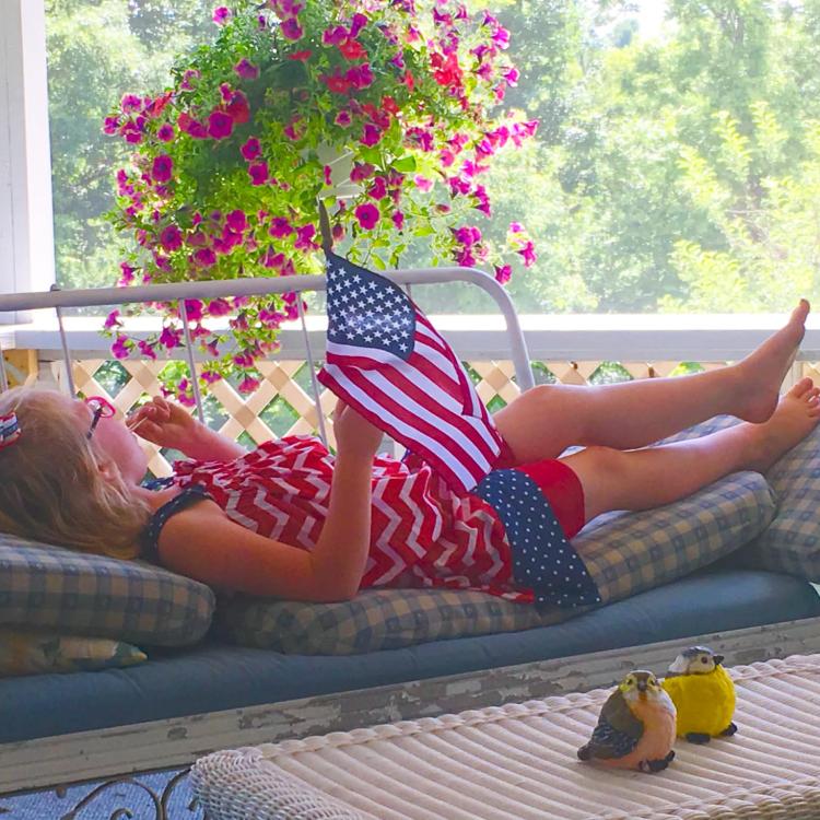 girl on porch with American flag
