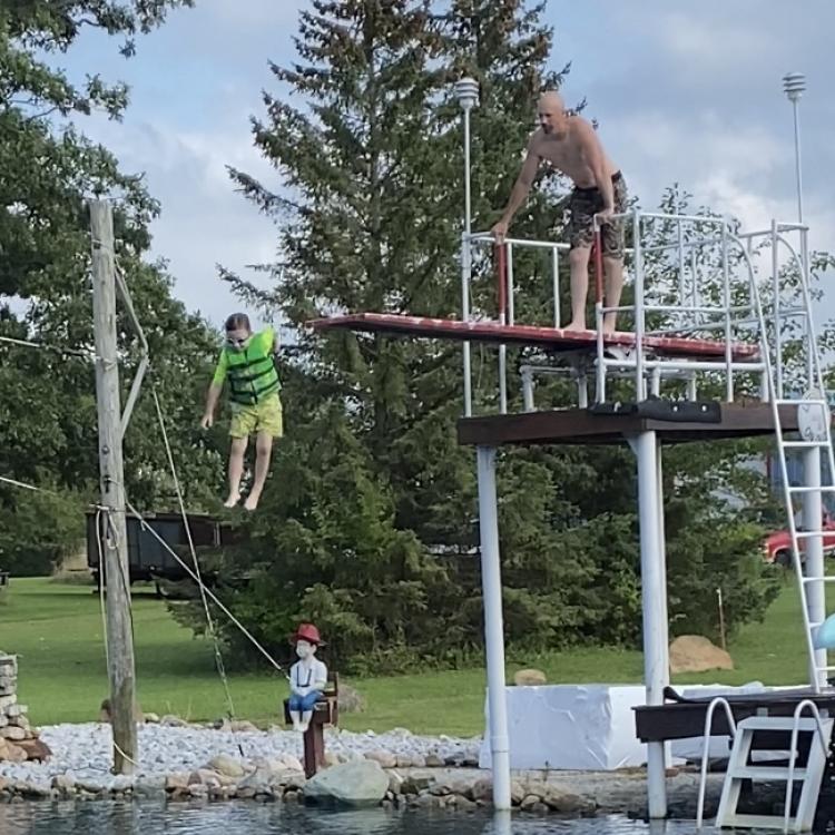 Boy jumps off high dive into lake