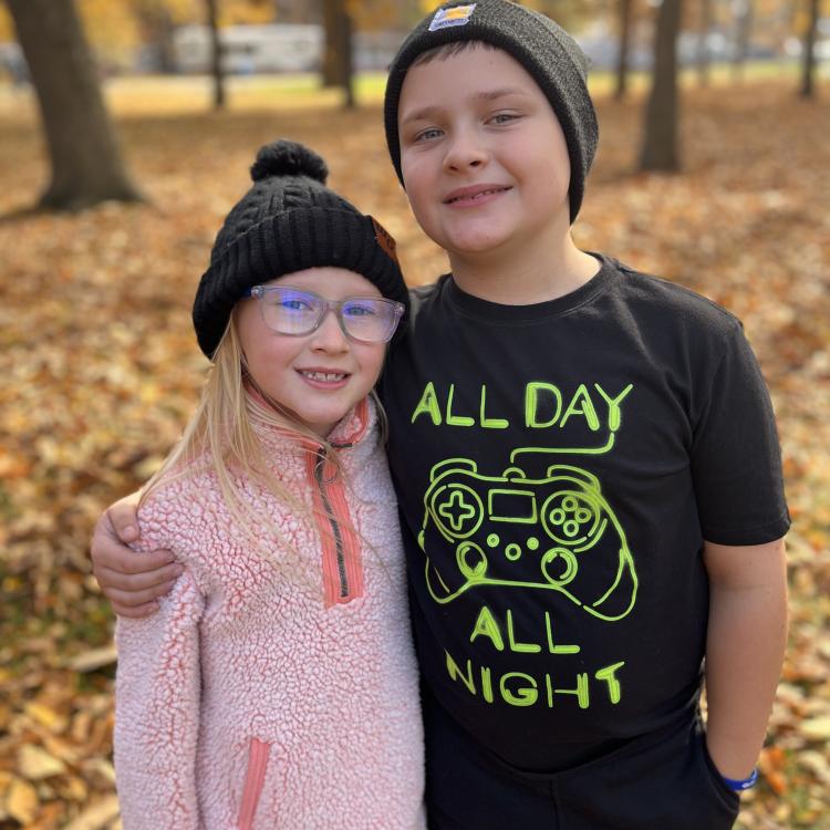two children standing in autumn woods