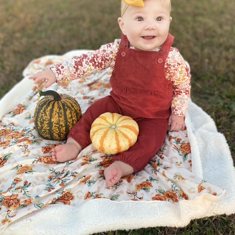 baby girl on blanket with pumpkins