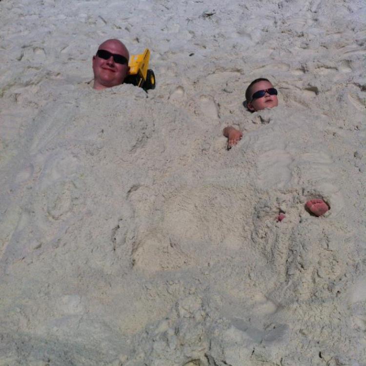 man and boy, buried in sand