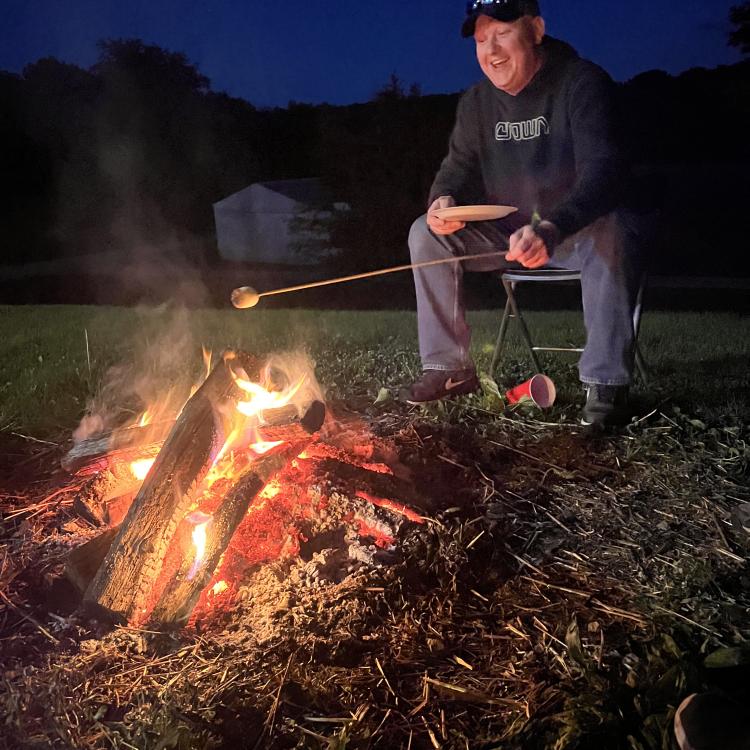 boy toasting marshmallow over a fire