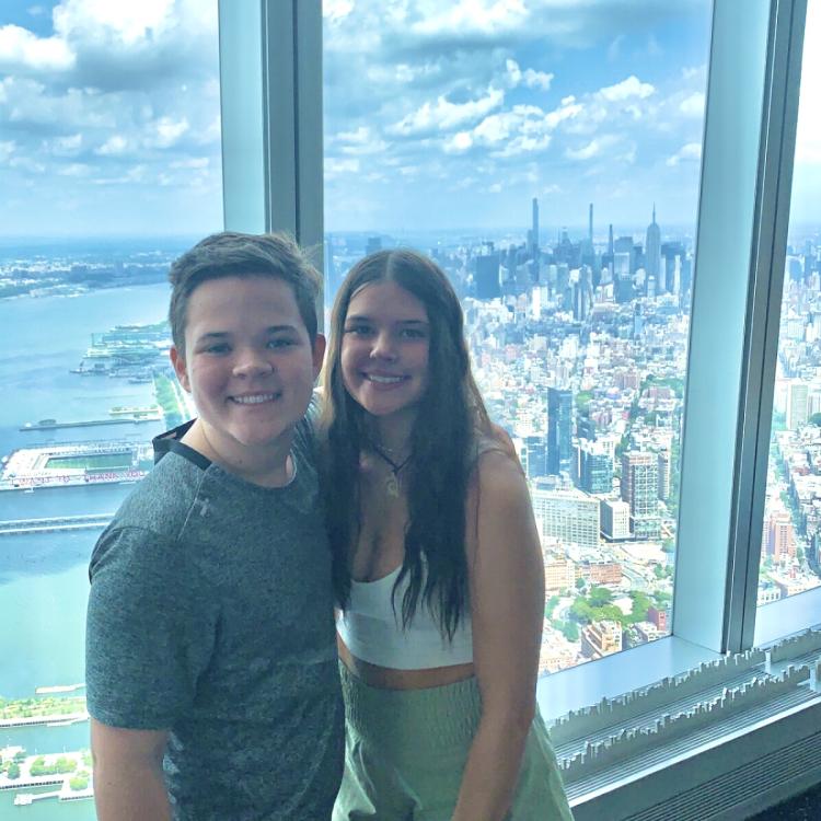 girl and boy in front of high window overlooking city