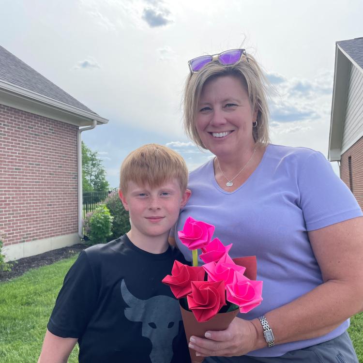 boy with woman holding pink flowers