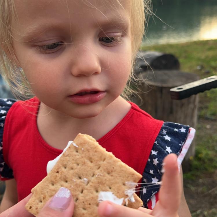 little girl holding sticky s'more