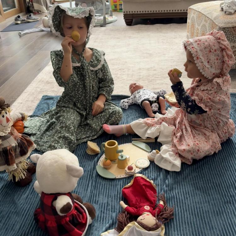 two girls having tea with toys
