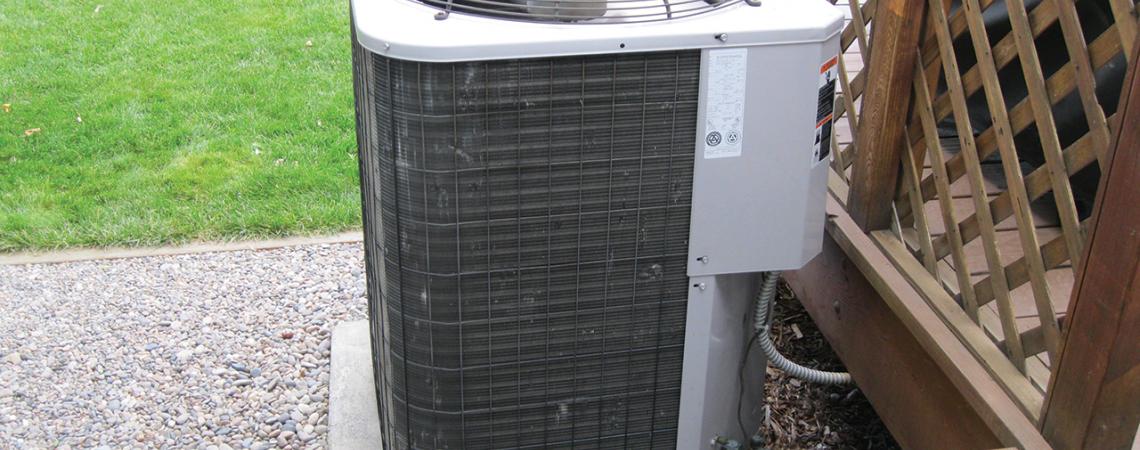 A picture of a heat pump outside of a home.