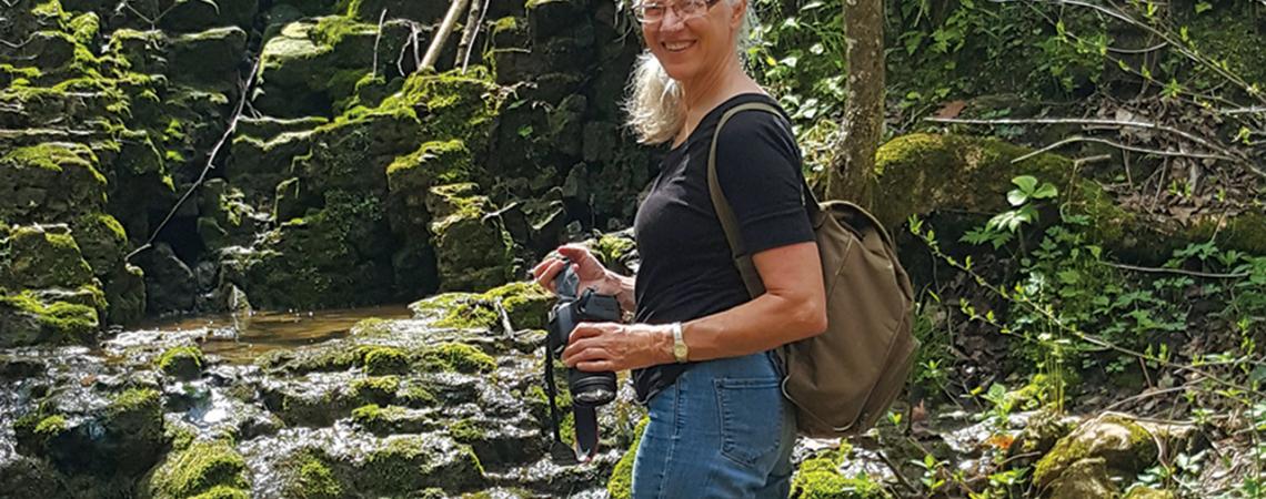 Nancy Stranahan, co-founder and director of Arc of Appalachia smiles for a photo in a forest