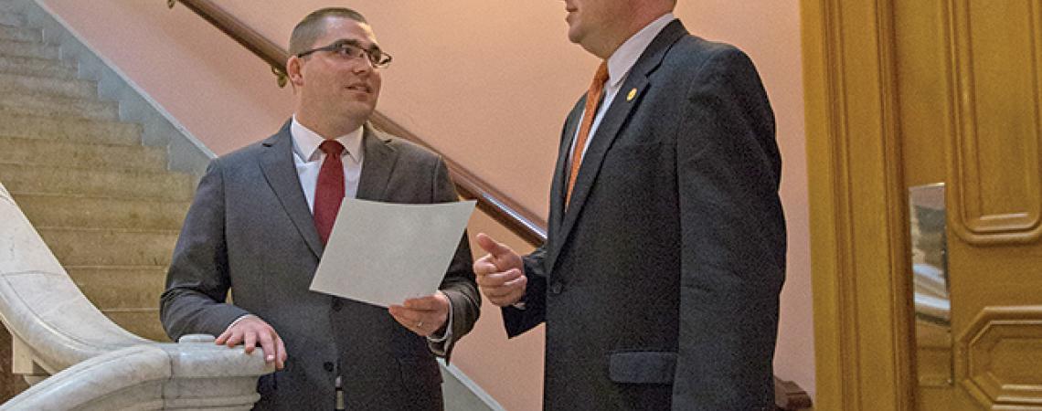 Marc Armstrong and Spencer Waugh talk on a staircase.