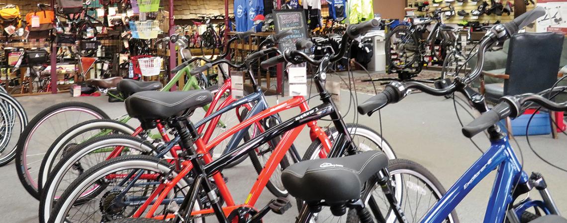 The inside of Bishop's Bicycles, containing multiple bikes, bags, and shirts.