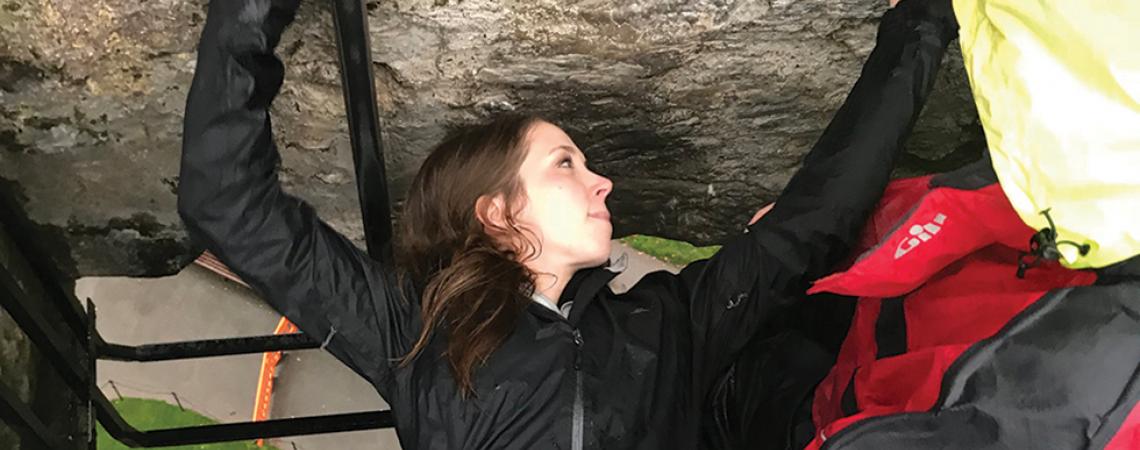 Samantha Kuhn, associate editor of Ohio Cooperative Living, climbs a rock.