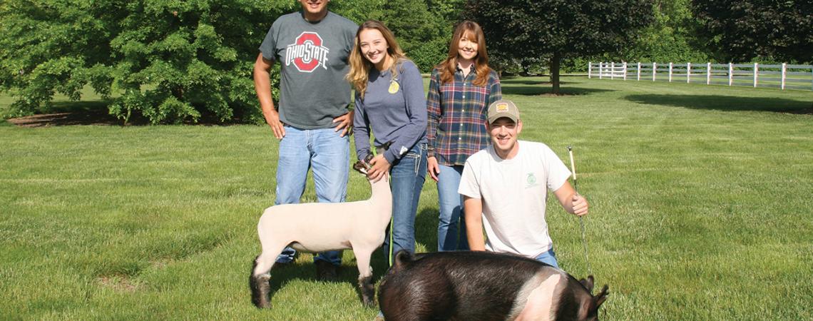 The Butterfield Family poses for a picture with their goat and pig.