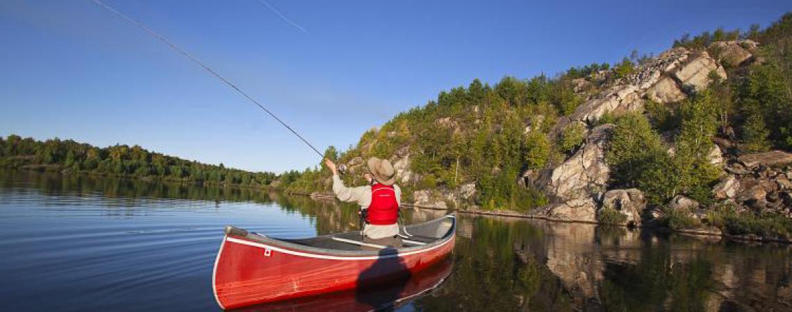 A man casting from a boat on Dog Lake.