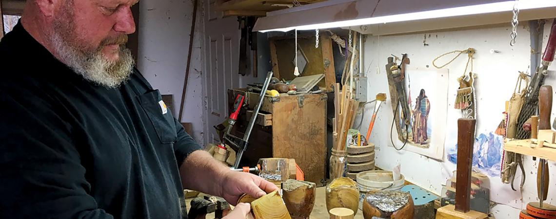 Ken Duerksen puts the finishing touches on a lidded box at his garage worktable. (Photo by Karen Holcomb)