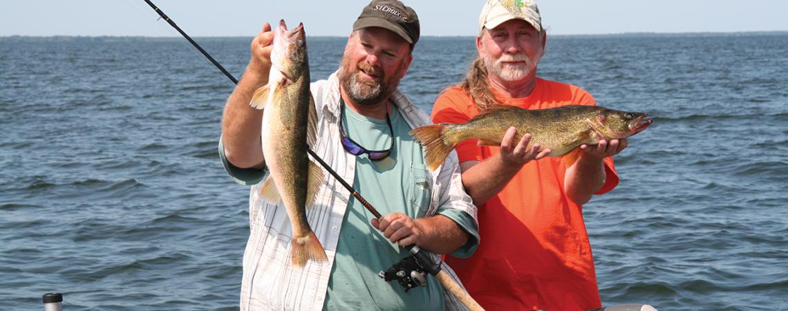 Fishing guide Dave Rose (left) and a client show off part of their catch of Green Bay walleyes during a day on the lake.