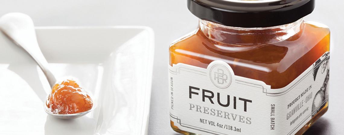 A jar of Black Radish Creamery's fruit preserves next to a plate and spoon.