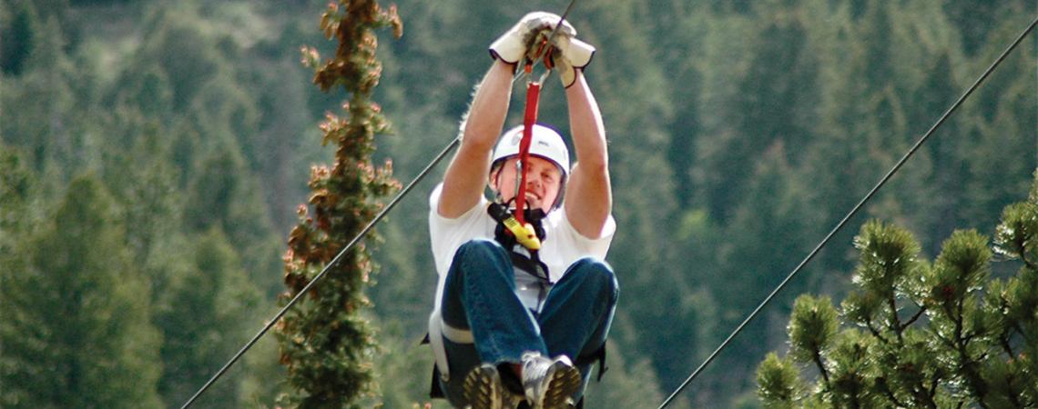 An individual smiles ziplining