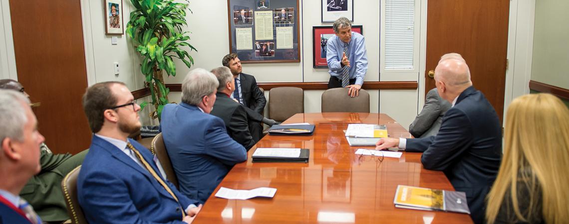 Cooperative leaders sit around a table talking with Senator Sherrod Brown