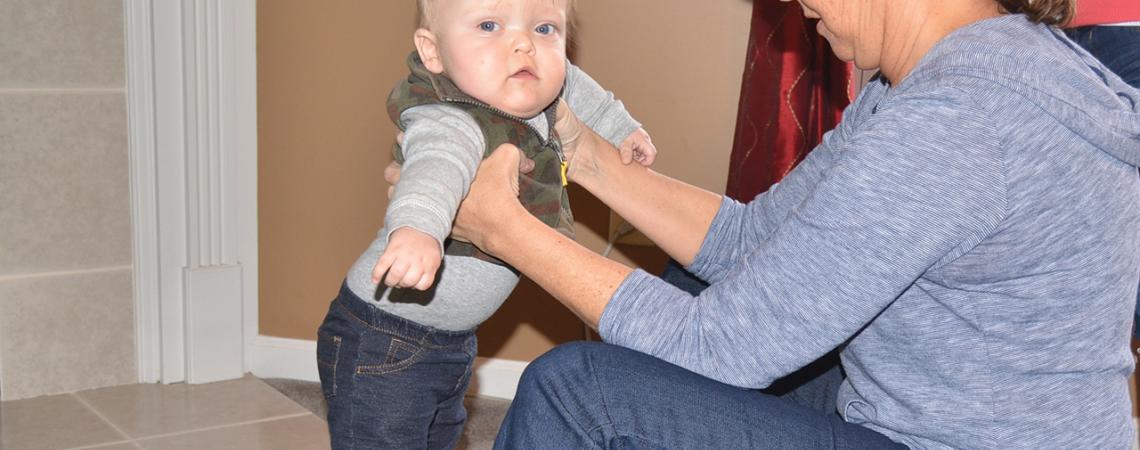 Kathy Fleenor, a pediatric physical therapist from the early-intervention division of Butler County Board of Developmental Disabilities, helps Lucas walk on the infant treadmill for the first time.