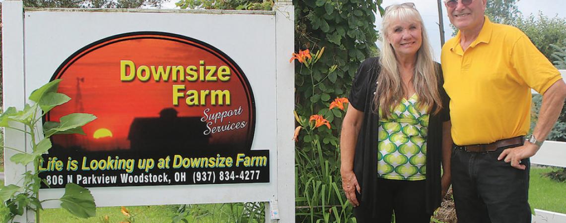 Midge and Bob Custer, of Woodstock, Ohio, pose next to the sign for their farm.