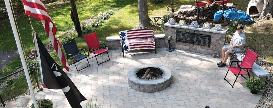 Gary Snyder seated in his backyard military memorial