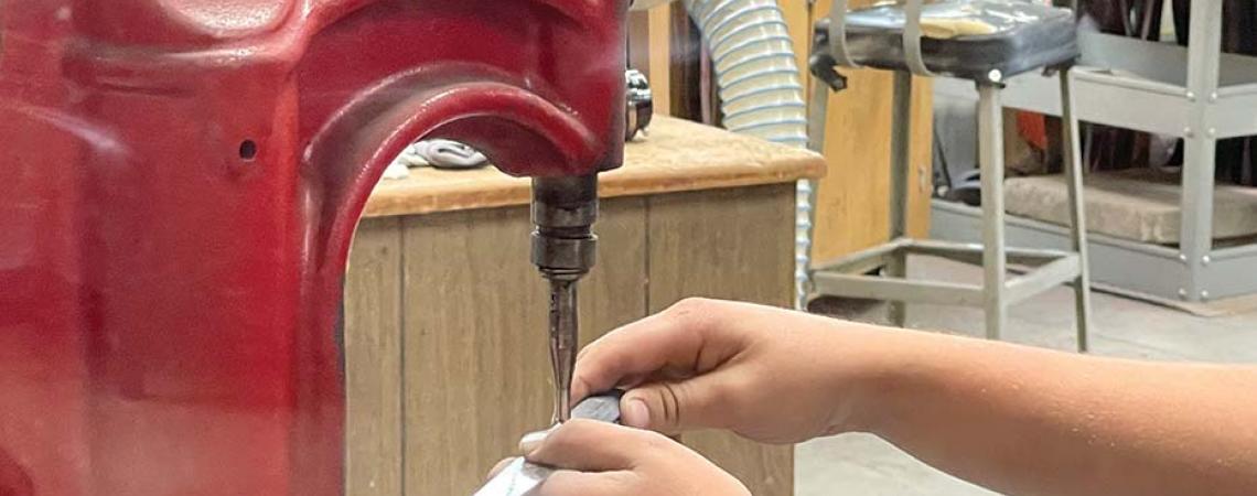 A Warther knife's hardwood handle being hand-riveted. 