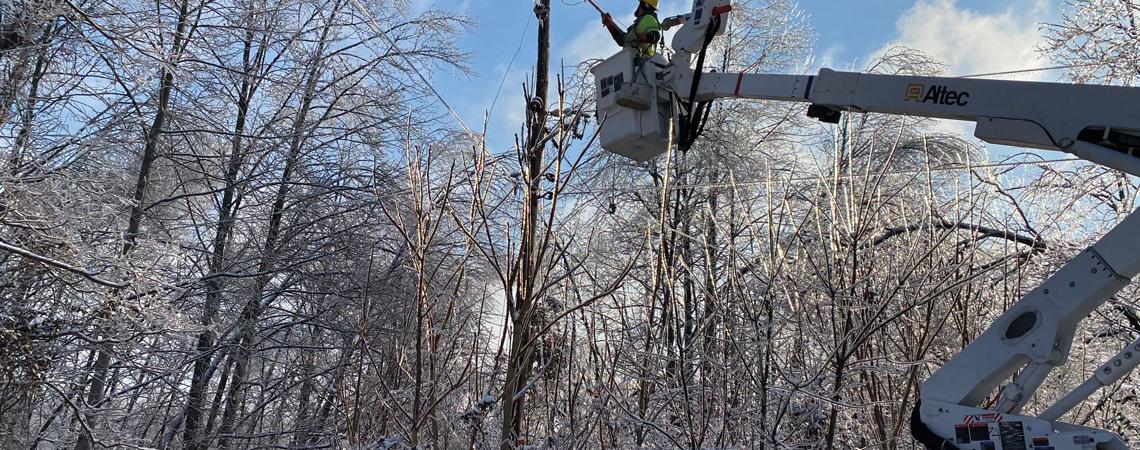 Lineworkers operating in icy, snowy weather.