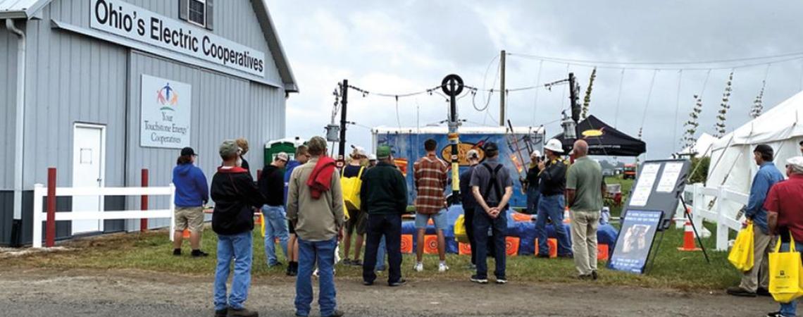 A small crowd gathers next to the Ohio’s Electric Cooperatives Education Building during the Farm Science Review to watch South Central Power Company’s live line safety demonstration.