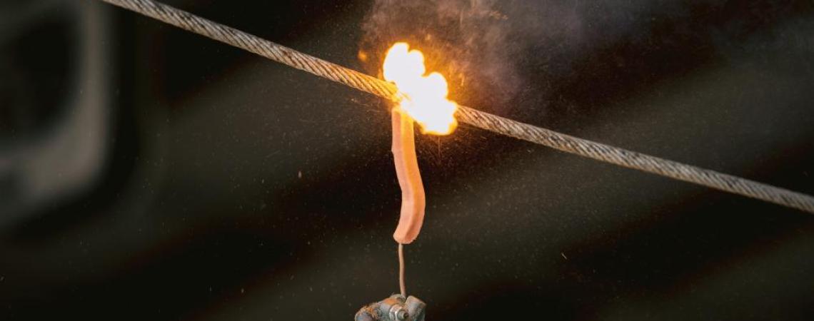 Lineworkers use a fully energized power wire to show the potential dangers of electrical contact — including the use of a hot dog to show what can happen if human skin touches a power line.