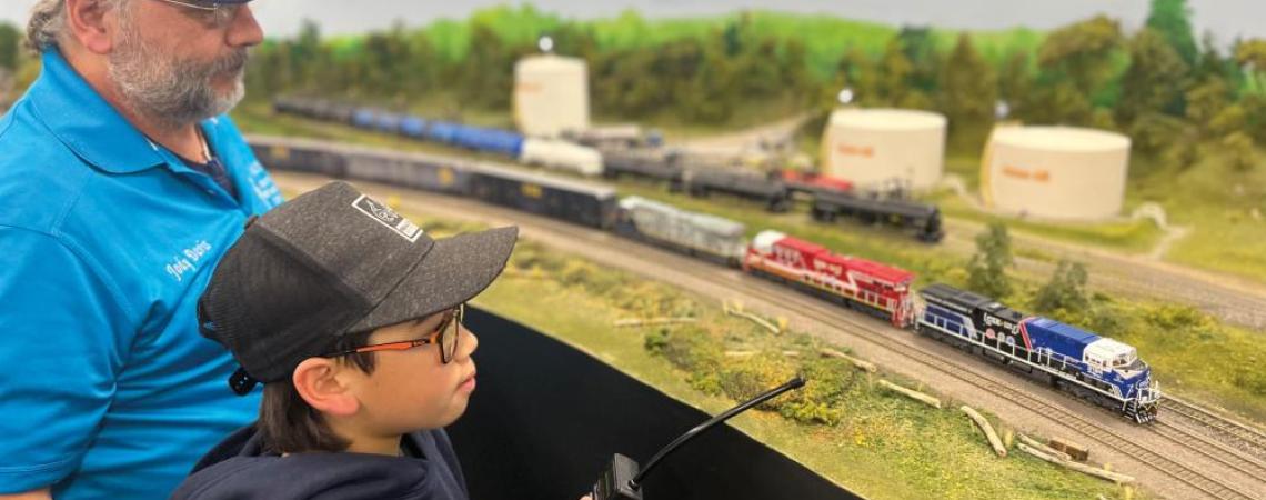 Model railroading is an intergenerational hobby. Here, Guernsey-Muskingum Electric Cooperative member Jody Davis shows Samson Hall the finer points of operating this HO-scale layout at a club meeting at the Coshocton County Fairgrounds (photo courtesy of Lance Hall). 