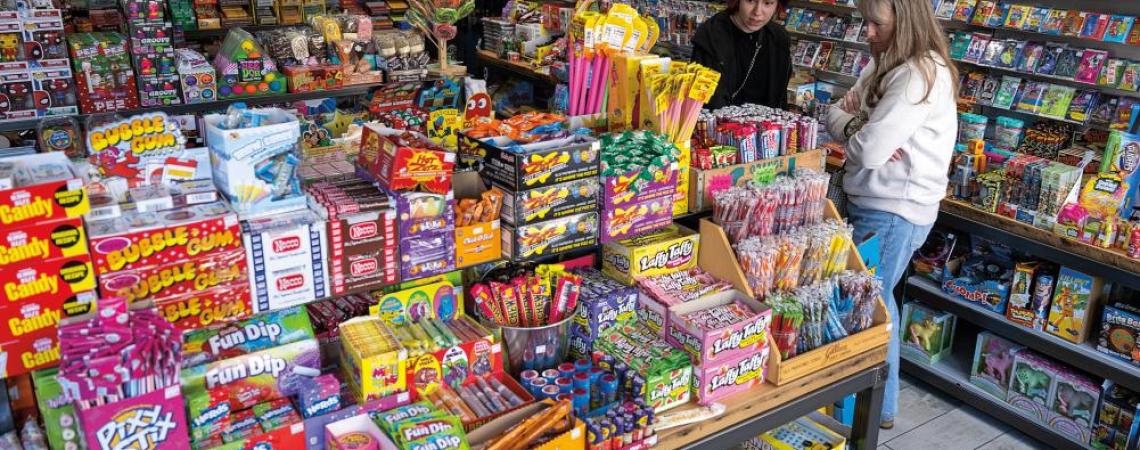 Customers at Rad Candy Company survey the retro candy offerings, including Pop Rocks, Necco Wafers, and Clark Bars. 