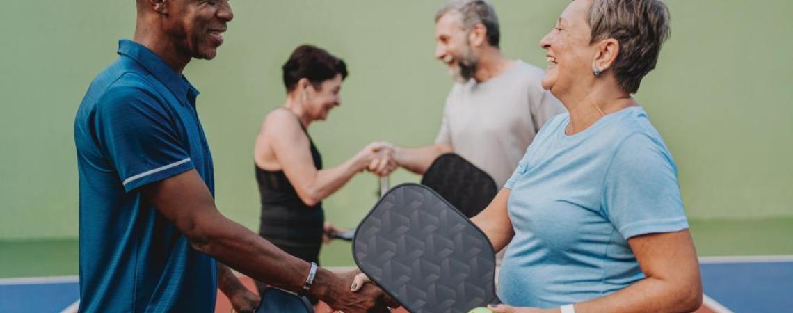 Two athletes shaking hands after a game of pickleball.